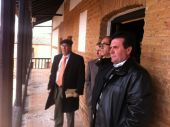 El alcalde de San Carlos del Valle con el delegado de agricultura frente a la fachada de la hospedería